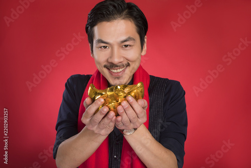 Obraz na płótnie Happy Asian Man Holding Golden Ingot for Chinese New Year
