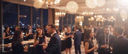 Business networking reception at evening gala with elegant professionals conversing with drinks in luxury high-rise ballroom, ideal for corporate PR and conference promotion
