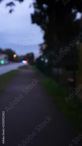A strobe light, a flashing emergency vehicle siren vertical, and a police car against a blurred background; a nighttime cityscape.