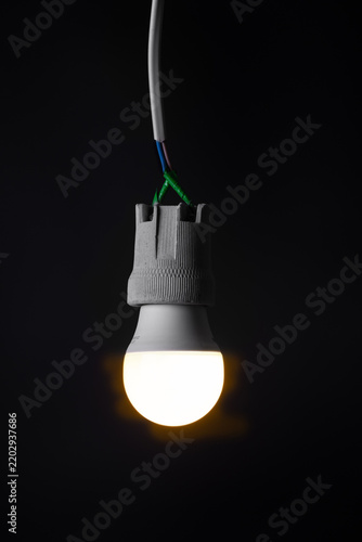 Glowing  light bulb close up on black background