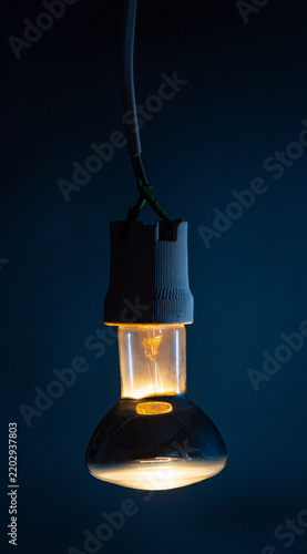 Glowing  light bulb close up on black background
