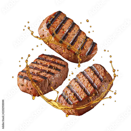 Three grilled beef steaks splashing in rich brown oil sauce on transparent backdrop.