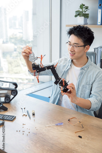 Engineer assembling a robotic arm in a modern office