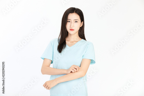 Young Woman Scratching Her Itchy Arm on White Background