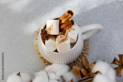 Foto hot chocolate with marshmallows and spices served in a white cup on a light surf