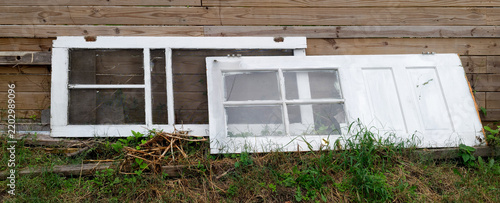 Discarded Vintage Doors Leaning Against a Wooden Fence
