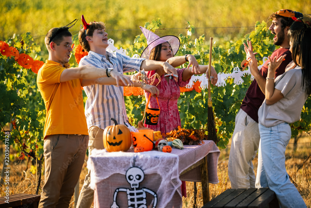 Obraz premium Group of young friends posing like zombies at a Halloween party outdoors in a vineyard.
