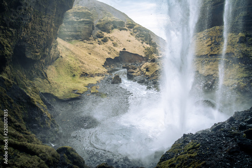 Kvernufoss waterfall seen from the rocks behind in the southern part of Iceland on a cloudy day in March
