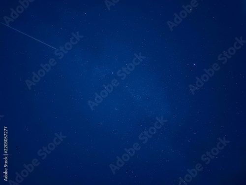 Cielo nocturno de color azul oscuro profundo salpicado de diminutas estrellas brillantes, transmitiendo serenidad, inmensidad y misterio cósmico.