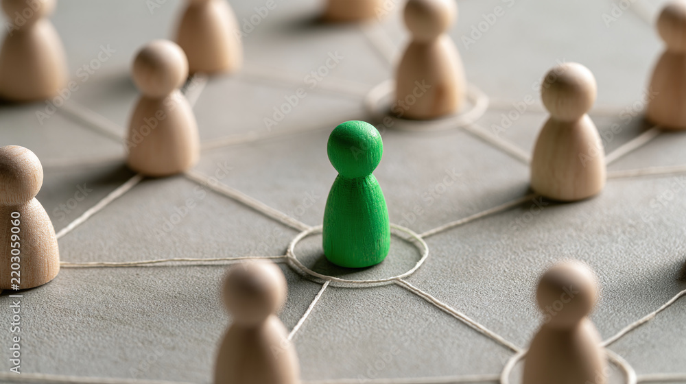 Obraz premium Wooden figures connected with string on a gray surface representing a business network concept with one distinct green pawn standing out from the crowd showcasing unique leadership and management role