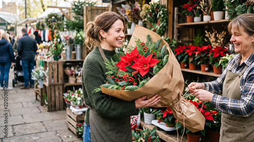 Happy woman buying festive poinsettia bouquet from florist at christmas market