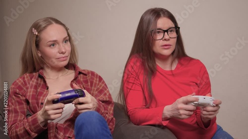 Women play games. Relaxed friends enjoying video games with cheerful interactions. Two women engage in friendly game night amid comfortable surroundings and joyful laughter