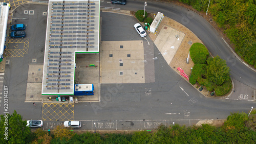 Aerial view of a gas station with solar panels on the roof and a white car parked at a pump in Bedford, England, United Kingdom.