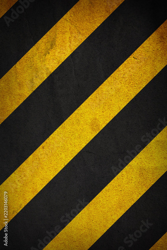 Industrial black and yellow striped grunge background with distressed texture. Abstract hazard stripe pattern. Suitable for warning themed graphics, construction projects, posters, banners, web design