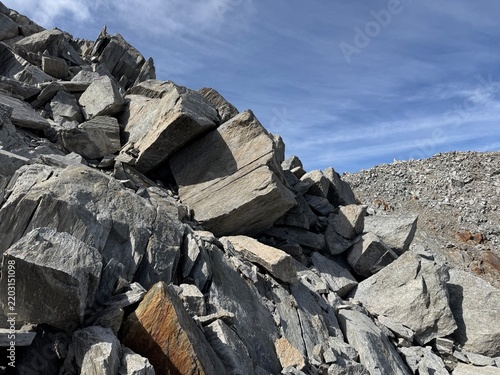 Rugged rock formations and giant granite boulders along a high-altitude hiking route in the Swiss Alps near Realp in the canton of Uri, showing steep cliffs, alpine terrain and dramatic geology