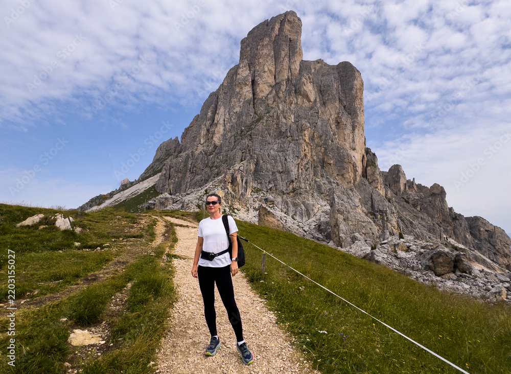 Obraz premium tourists walking in the dolomites at giau pass in summer italy