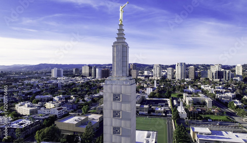 Aerial view of the Los Angeles California Temple with its iconic gold statue atop the white stone tower, surrounded by the urban landscape of Los Angeles, CA, United States.