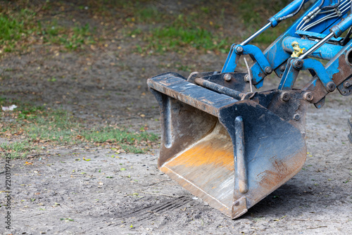 Canvastavla Excavator metal bucket rests on dirt ground in outdoor work site
