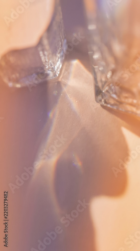 Abstract light refraction and prism effect with glass crystal shadows on a warm pastel peach background
