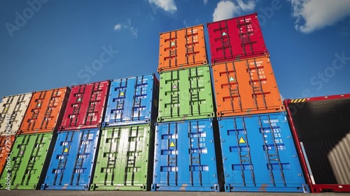 Row of colorful shipping containers in distribution port. Commercial logistics concept. 3D animation.