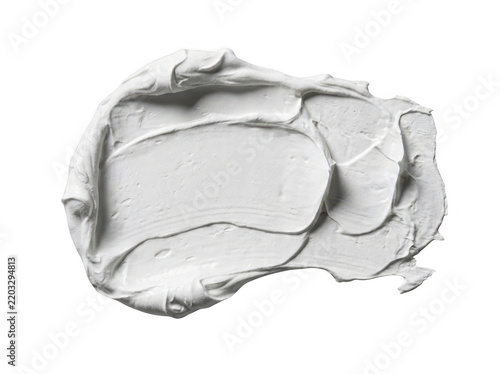 A glob of white paint or cream spread on a smooth transparent surface with organic texture.