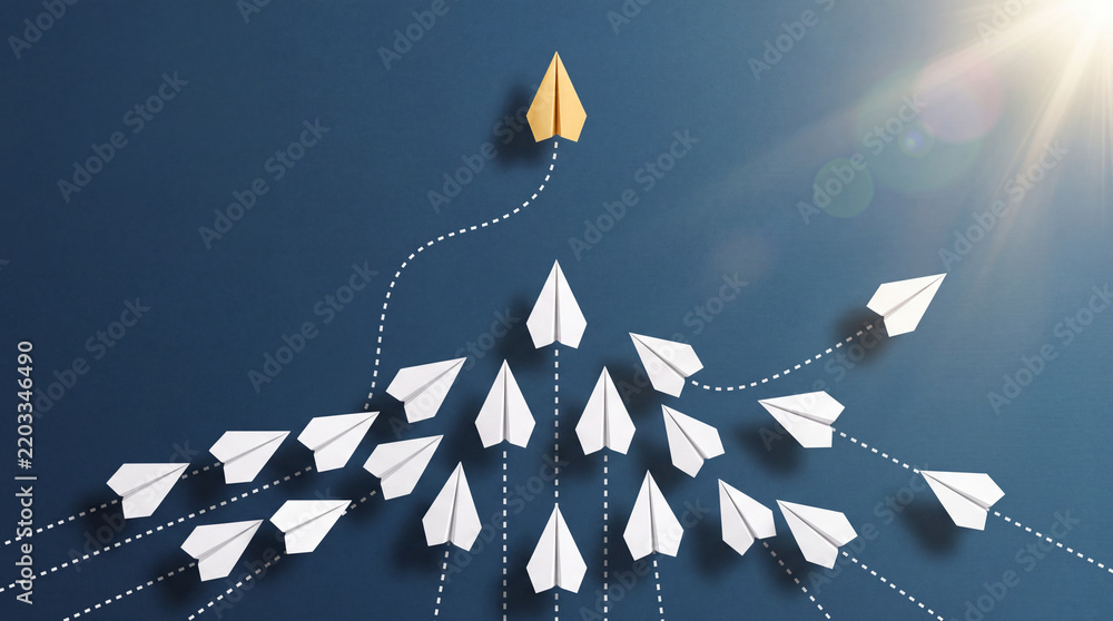 Fototapeta premium Unique Gold Paper Plane Leading White Paper Planes on Blue Background, Concept for Leadership, Business Innovation, Success, Management, and Strategic Direction towards New Goals and Solutions