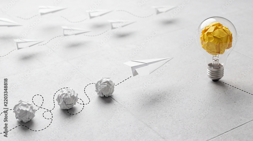 Obraz premium Conceptual business innovation and creativity concept with a yellow paper light bulb as a bright idea symbol and white paper planes representing the journey from failed attempts to success.