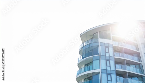 Modern residential building with glass facade and curved balconies in urban setting with bright daylight