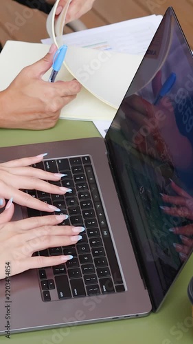 Business Colleagues Typing on Laptop and Reviewing Documents at Outdoor Table