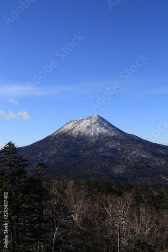 Snow-covered summit of Mount Oakan under blue sky in Hokkaido, Japan