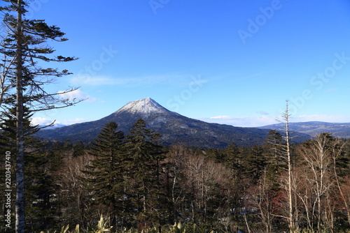 Snow-capped Mount Oakan rising above the forest in Hokkaido, Japan