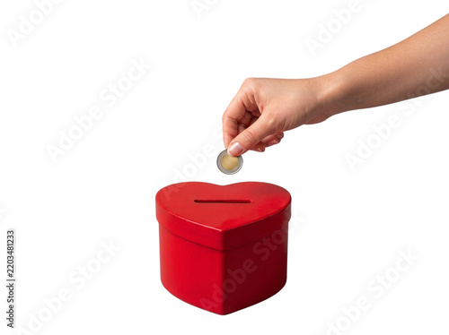 Woman's Caucasian hand putting coin in red heart shape donation box