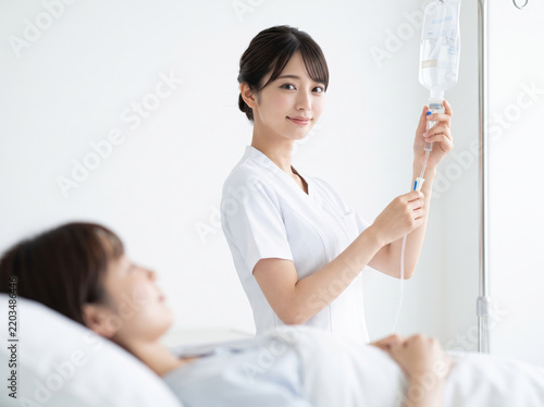Plakat 点滴のチューブを調節する優しい笑顔の女性看護師