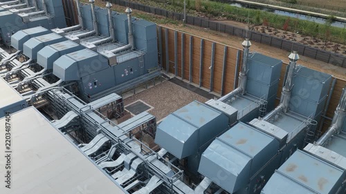 Large Data Center exterior site featuring rows of industrial cooling units and complex ventilation systems installed within a fenced perimeter for secure operations and temperature control.