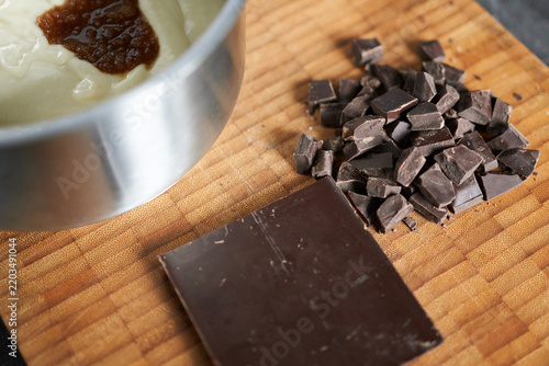 Preparing dough with dark chocolate chunks on a wooden board. Close-up.