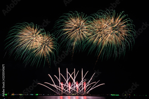 Vibrant Fireworks Exploding Over Calm Ocean Water During An Evening Festival Celebration To Create A Spectacular Pyrotechnic Display In The Dark Night Sky