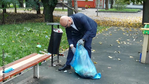 Volunteer businessman cleaning up garbage in park