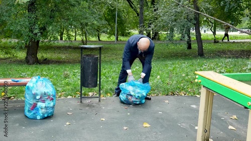 Volunteer businessman collecting plastic waste in a park