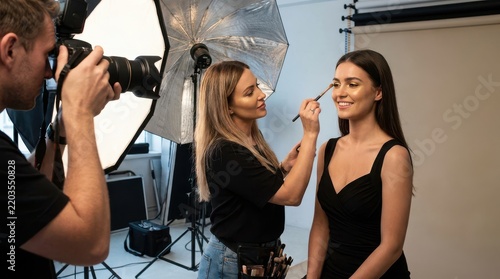 Professional makeup artist preparing model for studio photo shoot