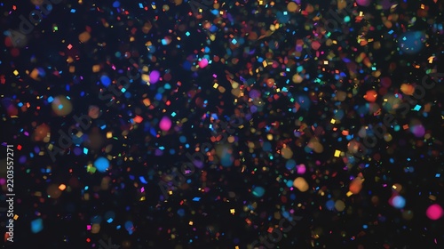 Colorful abstract light particles on dark background.