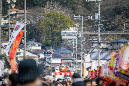 Fotografie view of a crowded Japanese street market festival with a giant red daruma doll a