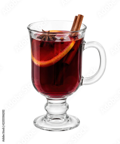 Clear glass mug filled with dark red mulled wine, garnished with orange slice, star anise, and cinnamon sticks, isolated on a white background