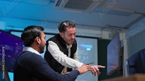 Diverse Software Engineers Collaborating on AI System Orchestration Screen