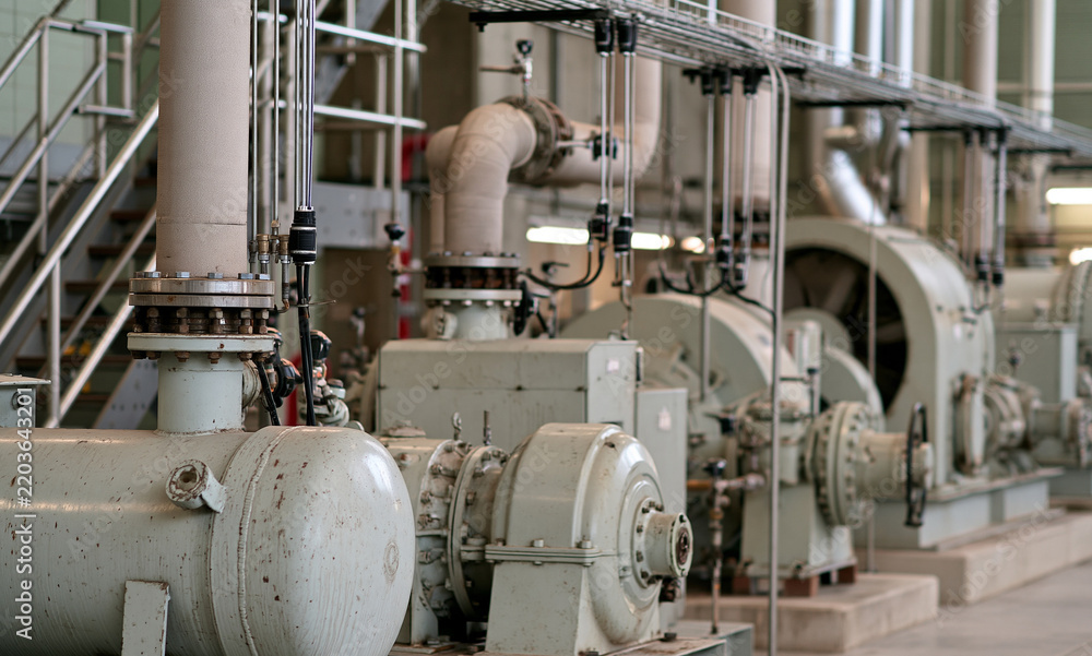 Fototapeta premium interior of an operating industrial plant utility room, several different types of power-consuming equipment in active service a large air compressor