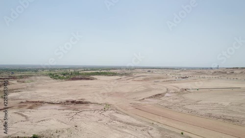 Extensive graded land and dirt access routes spread across a large undeveloped construction area