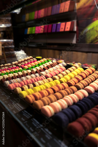 Elegant pastry shop storefront featuring colorful macaron towers and artisan desserts