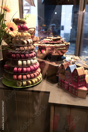 Elegant pastry shop storefront featuring colorful macaron towers and artisan desserts