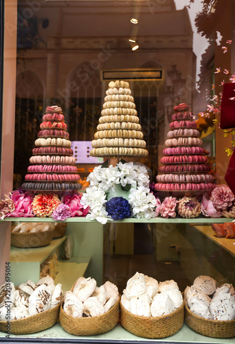 Elegant pastry shop storefront featuring colorful macaron towers and artisan desserts