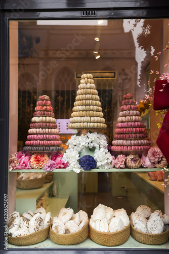 Elegant pastry shop storefront featuring colorful macaron towers and artisan desserts