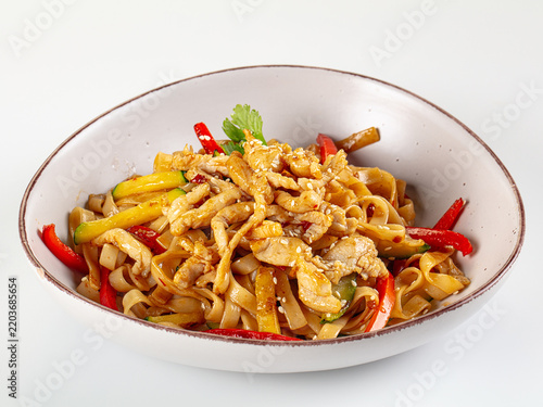 Konstfotografi Stir fried chicken with rice noodles, red bell pepper, zucchini and sesame seeds